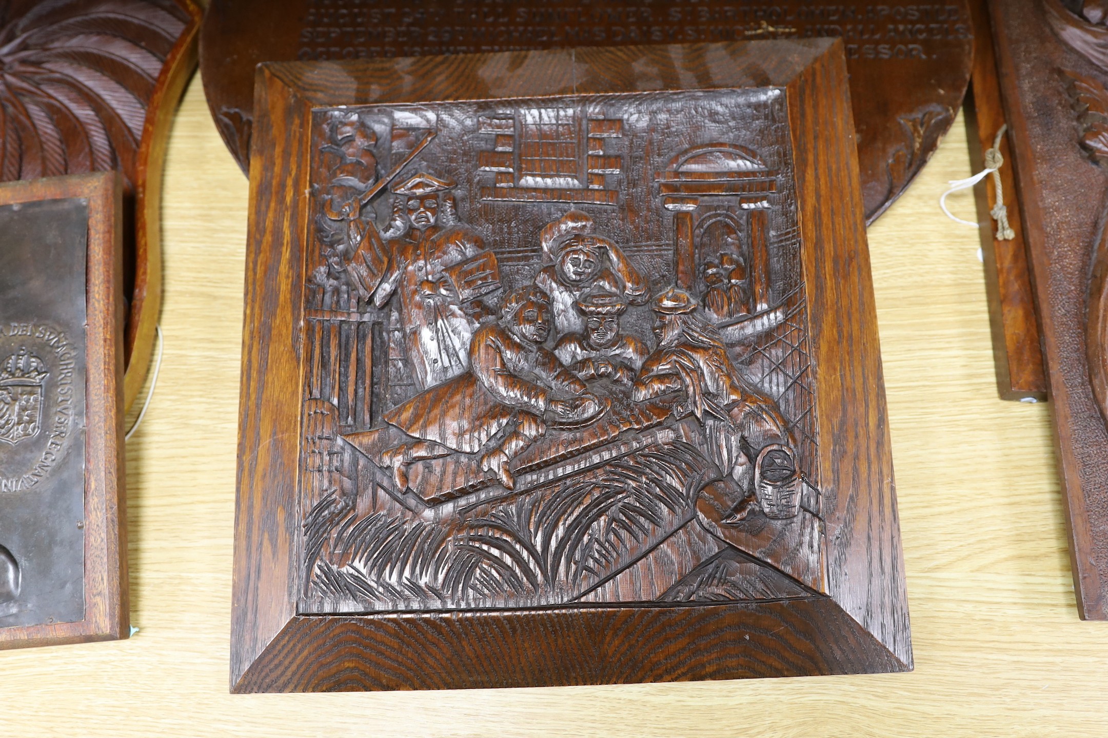 Six mixed oak carved panels and a metal relief mounted panel